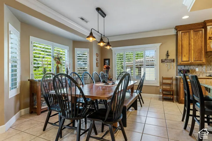 Tiled flooring, bay window with plantation shutters, coffered ceiling, and kitchen with wood cabinetry