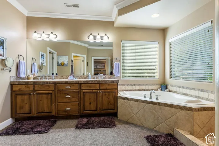 Dual sink vanity with wood-finish cabinetry and a built-in jetted tub with tile surround