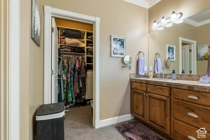 Double vanity with wood-finish cabinetry, tile countertop, and full-width mirror