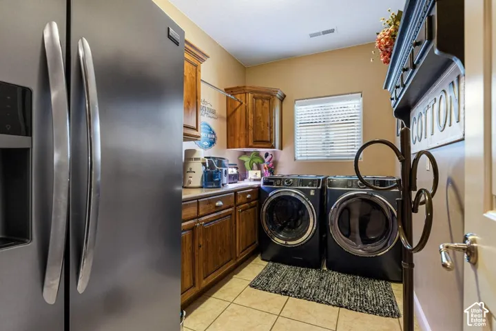 Built-in cabinetry with wood finishes, integrated front-loading appliances, and a tiled floor