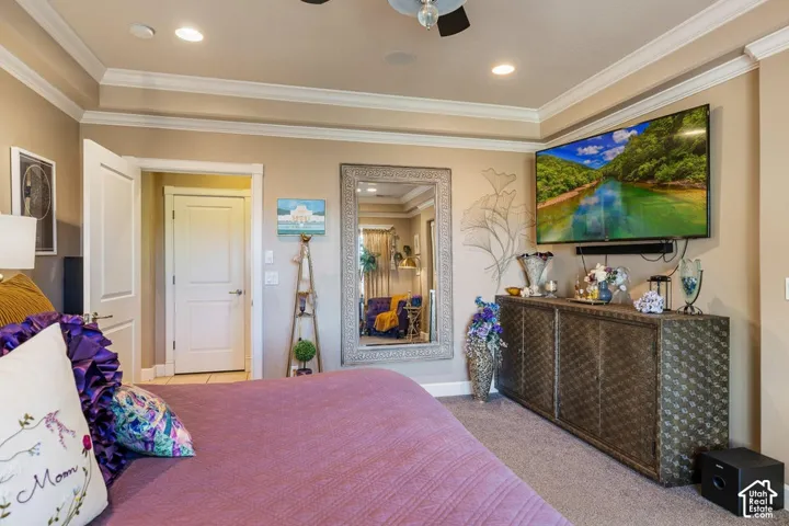 Recessed lighting illuminates the tray ceiling with crown molding