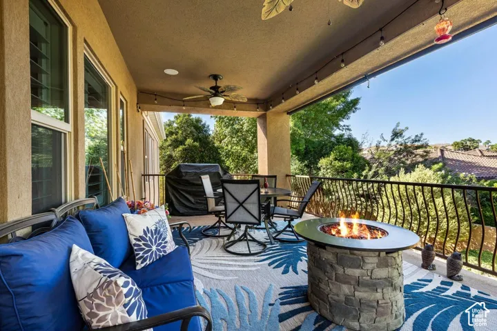 Covered patio featuring an exterior ceiling fan, recessed lighting, string lighting, and an ornamental metal railing