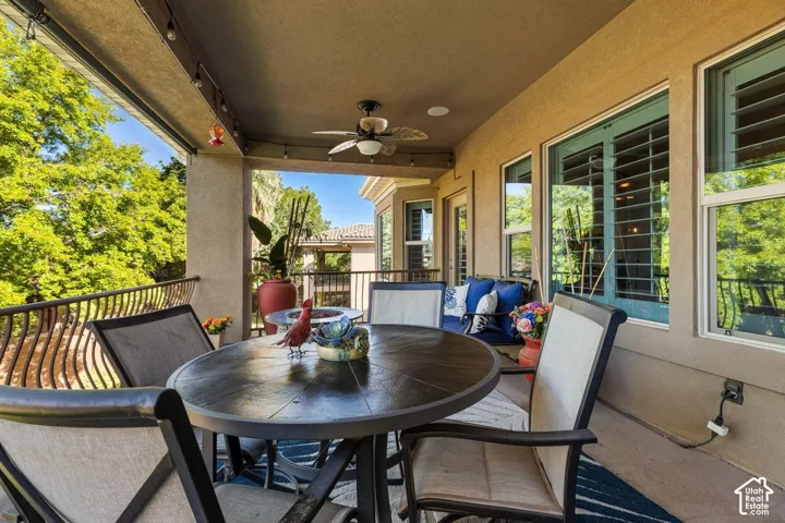 Covered outdoor patio with a ceiling fan, recessed lighting, and ornate metal railings