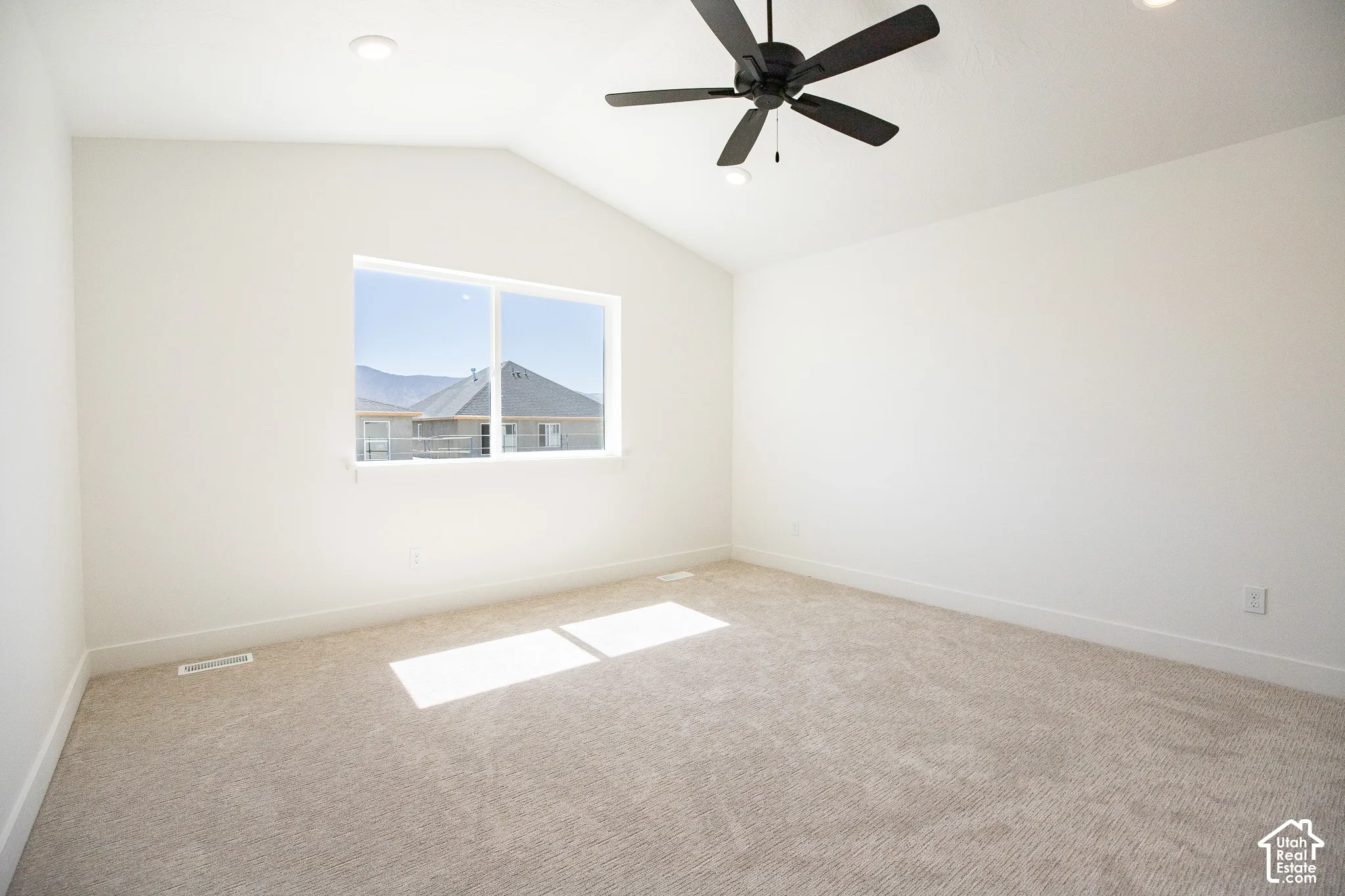 Primary bedroom with vaulted ceiling, ceiling fan and walk-in closet as part or primary suite.