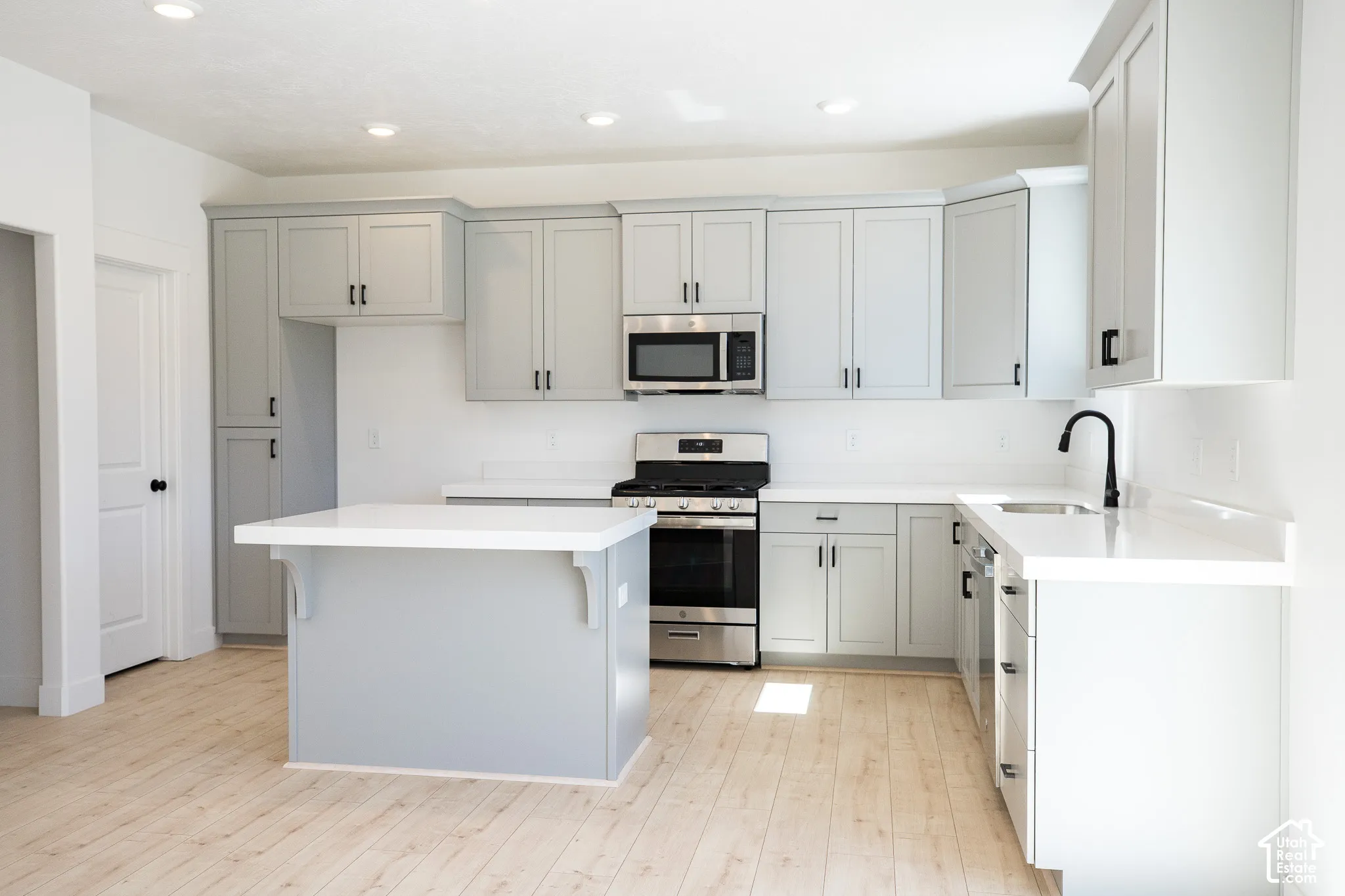 Terrific kitchen with 42" uppers, painted wood cabinetry, quartz slab countertops, walk-in pantry, gas range, microwave, dishwasher and disposal, adjacent to open dining area.