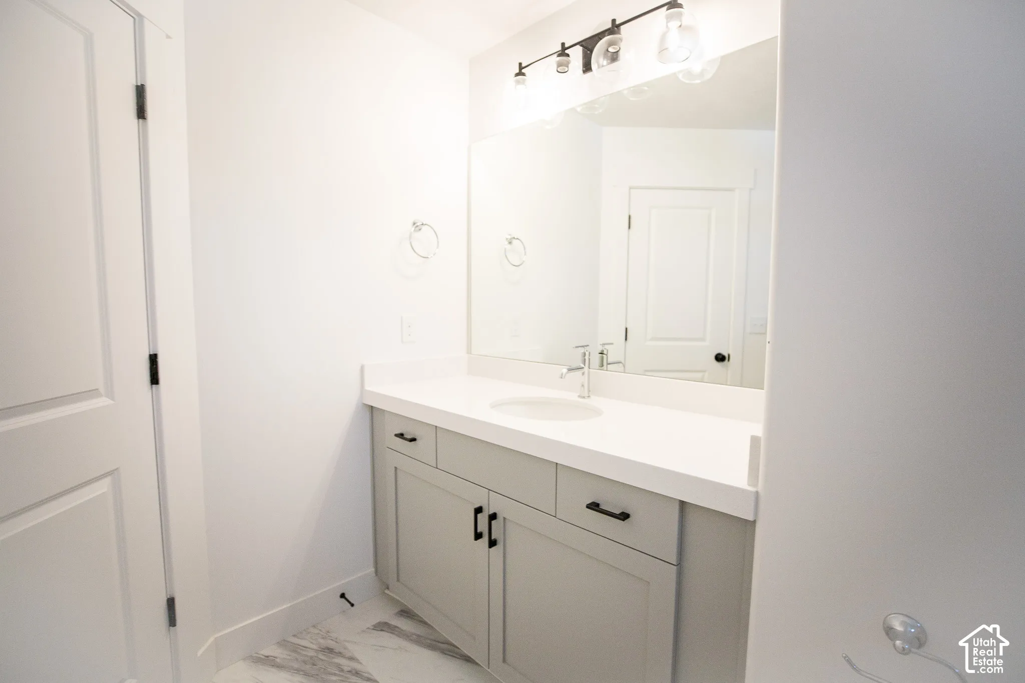 Full secondary bath with painted wood cabinets and quartz slab countertops.
