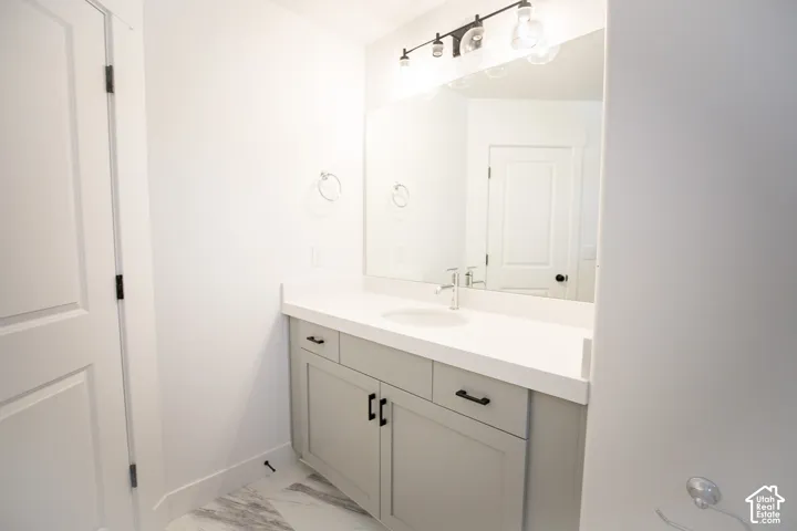 Full secondary bath with painted wood cabinets and quartz slab countertops.