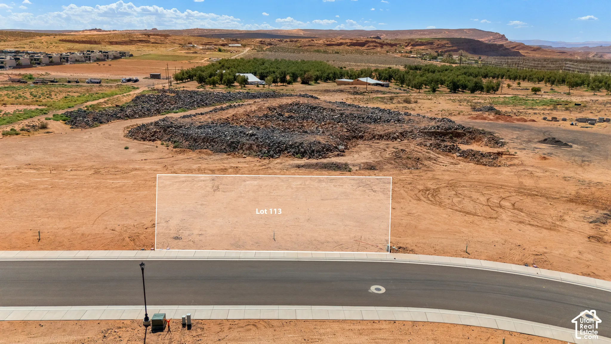 Graded lot featuring a paved road and sidewalk in the foreground