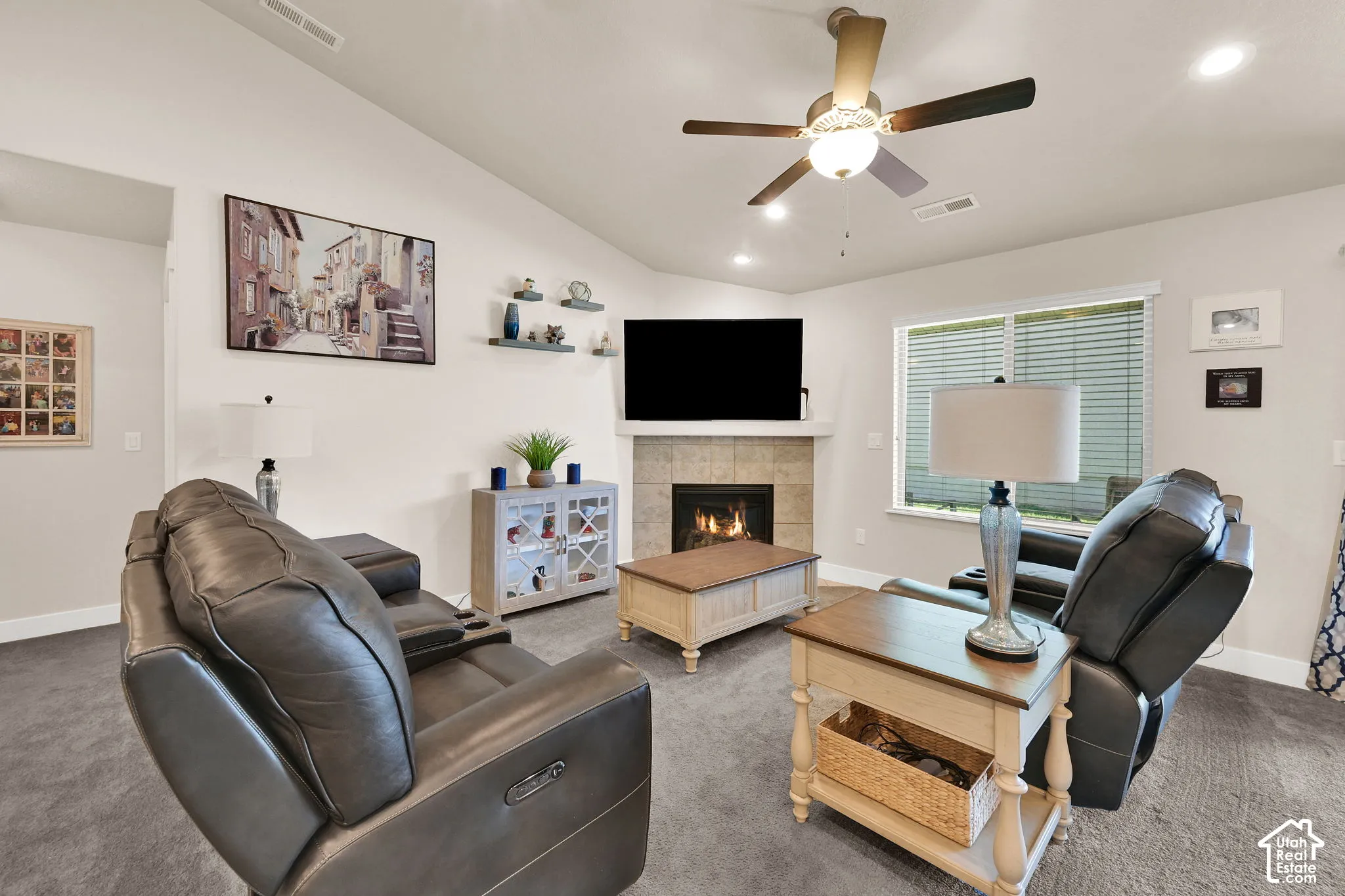 Vaulted ceiling with a ceiling fan, recessed lighting, and a corner fireplace featuring a tile surround