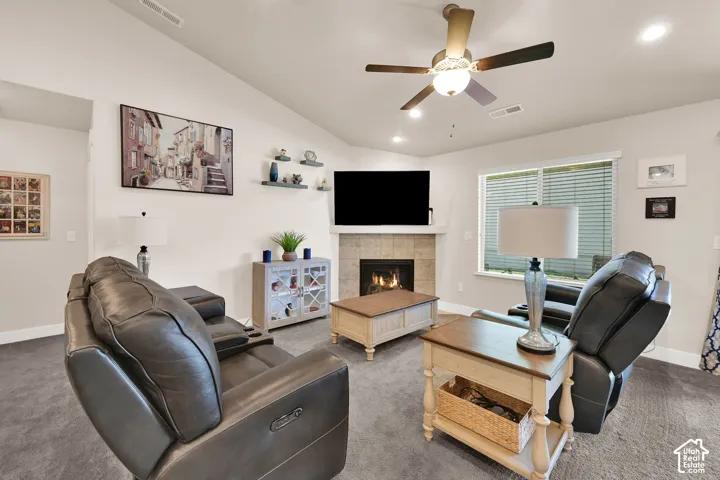 Vaulted ceiling with a ceiling fan, recessed lighting, and a corner fireplace featuring a tile surround