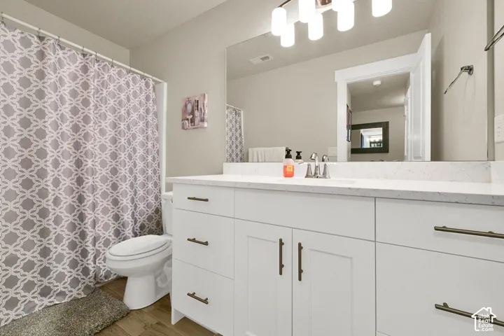 White vanity with multiple storage drawers and cabinet doors, large mirror, and a white countertop
