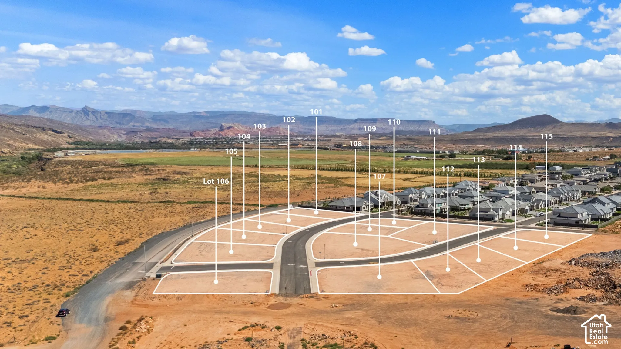 Planned community lots with paved roads, surrounding natural landscape, and distant mountain ranges