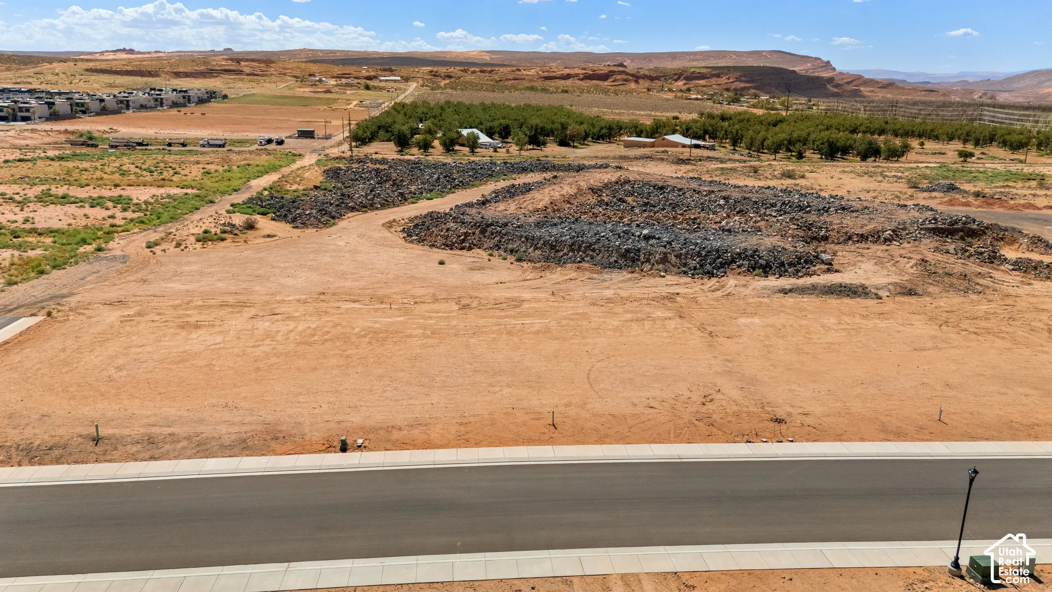 Graciously-sized buildable lot featuring a paved roadway, concrete sidewalk, and established utility connections
