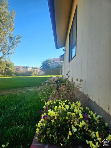 Manicured lawn with a landscaped flower bed, featuring a side exterior wall and window