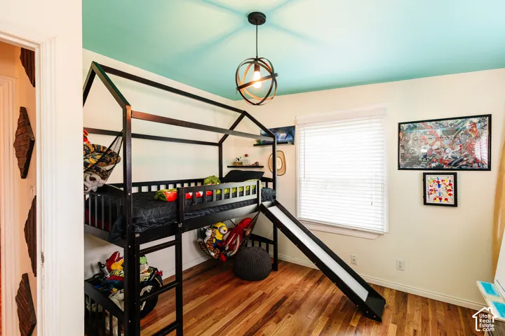 Wood-finish flooring with a light-toned finish, complemented by light wall paint and a contrasting blue ceiling