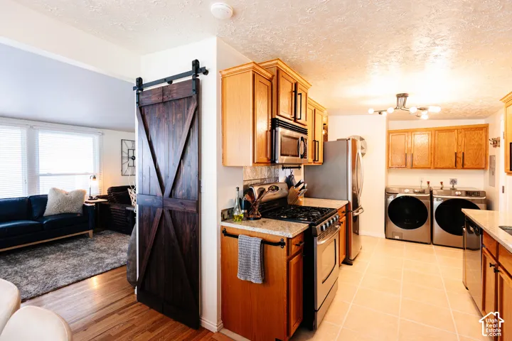 Kitchen featuring wood cabinetry, stainless steel appliances, and light-toned tile flooring