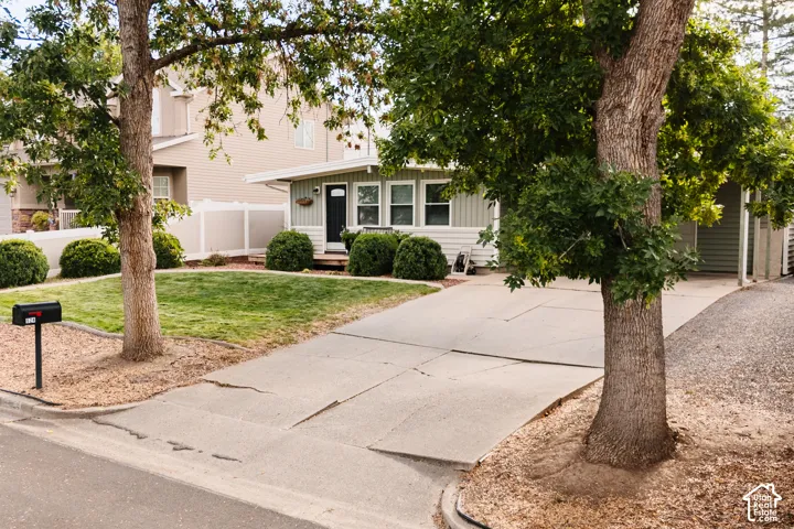 Light-colored exterior siding with white trim, a dark front door, and a well-maintained lawn