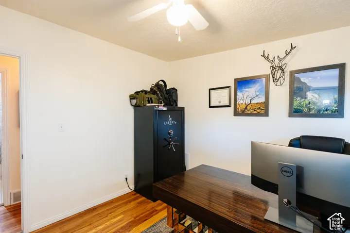 Hardwood-style flooring, a ceiling fan with integrated lighting, and a white interior door frame