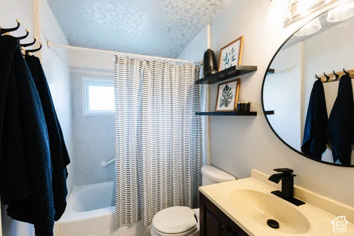 Bathroom featuring a vanity with an integrated sink, matte black faucet, and a circular mirror