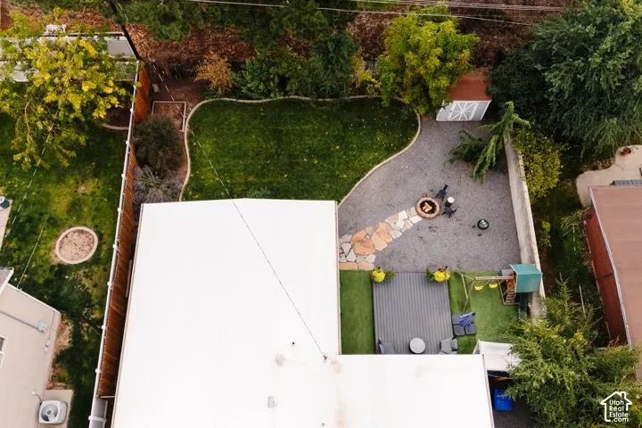 Expansive backyard featuring a manicured lawn, gravel patio with stone paver pathway, and a wood storage shed