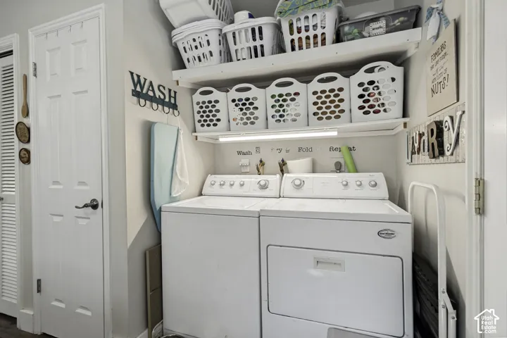 Dedicated laundry space featuring a white washer and dryer, integrated shelving, and a six-panel interior door