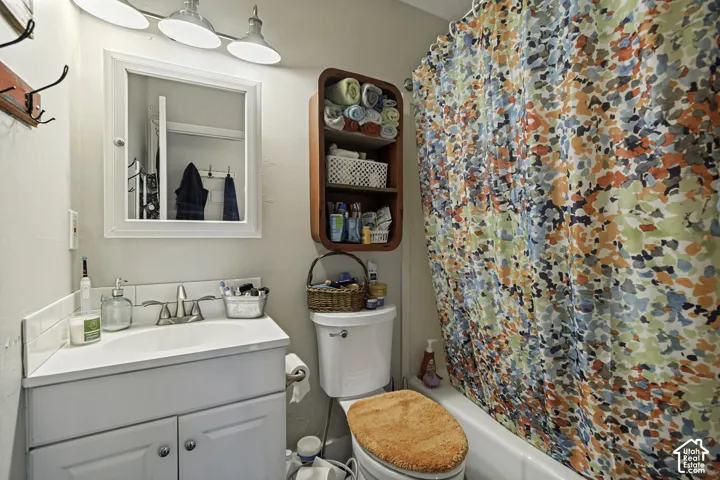 White vanity with integrated sink, chrome faucet, wall-mounted mirror, and overhead lighting fixture