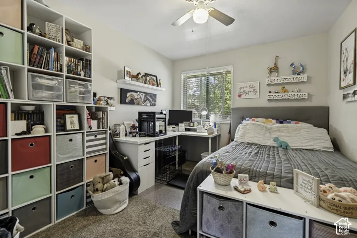 Built-in shelving units, ceiling fan, window with blinds, wall-mounted shelving, and wood-finish flooring