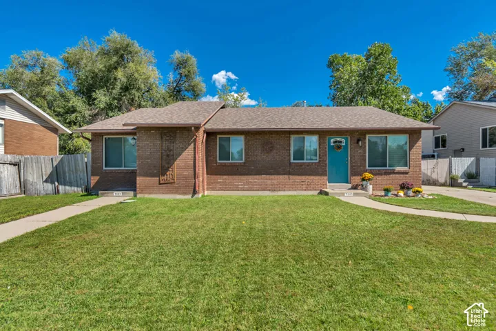 Brick exterior, asphalt shingle roof, dual pane windows, concrete walkway, and a concrete driveway