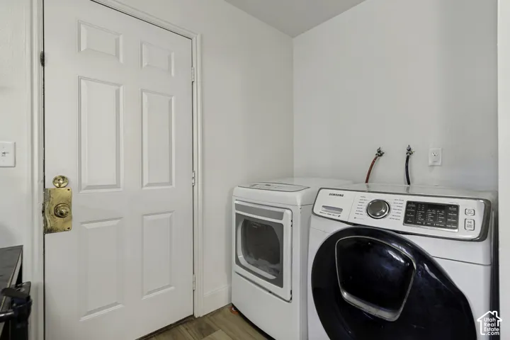 Dedicated laundry area with a panel door and wood-finish flooring