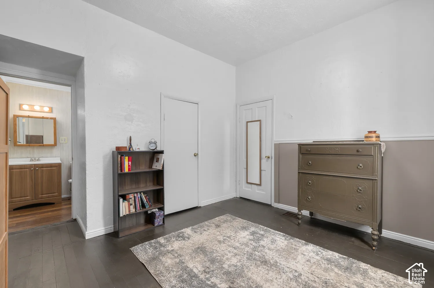 Dark wood-finish flooring with white walls and wainscoting