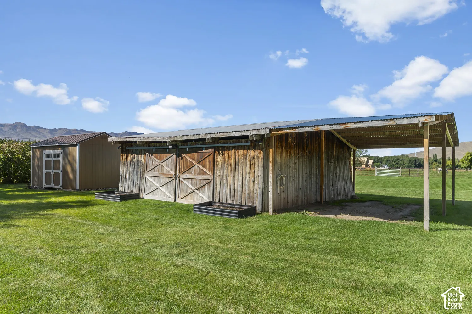 Wood-sided barn with sliding doors and an attached shed roof overhang