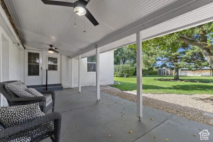 Covered patio with a concrete surface, supported by white posts, and featuring a white paneled ceiling