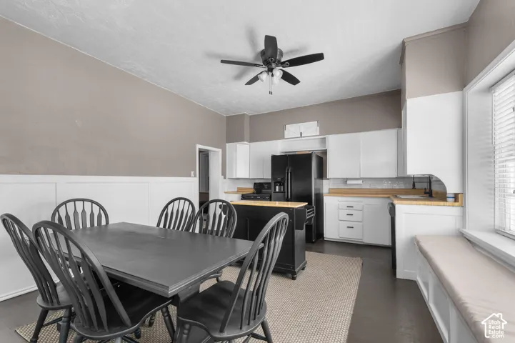 Kitchen featuring white cabinetry, light wood-finish countertops, and a full suite of black appliances