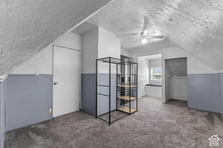 Carpeted flooring with a contrasting paint scheme, sloped ceilings, and a built-in window seat