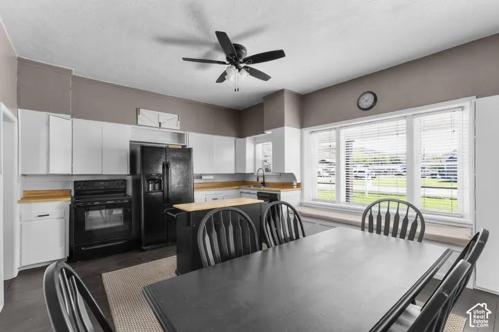 Kitchen featuring dark wood-finish flooring, white cabinetry, light wood countertops, and a ceiling fan with integrated lighting