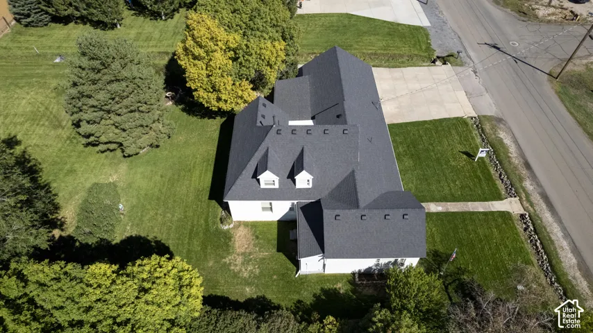 Expansive grass lawns with mature trees, a multi-gabled roofline, and dormer windows