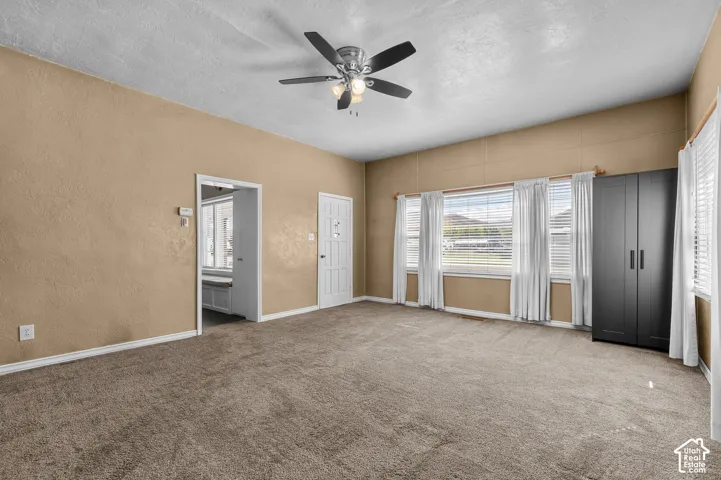Carpeted living space with a ceiling fan light fixture