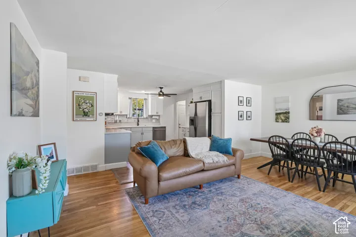 Hardwood-finish flooring, white painted walls, white ceiling, and an arched mirror