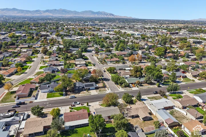 Expansive residential community featuring mature trees, paved streets, and mountainous backdrop
