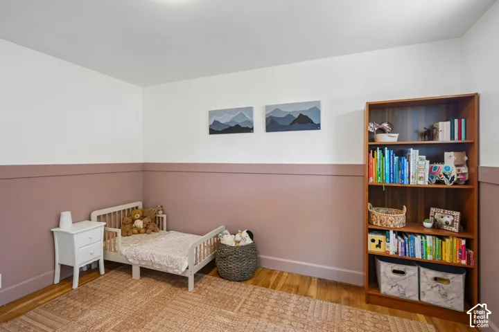 Hardwood flooring, two-tone wall treatment, built-in shelving, and overhead lighting
