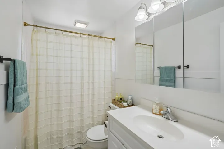 White vanity with integrated sink, chrome faucet, and mirrored medicine cabinet