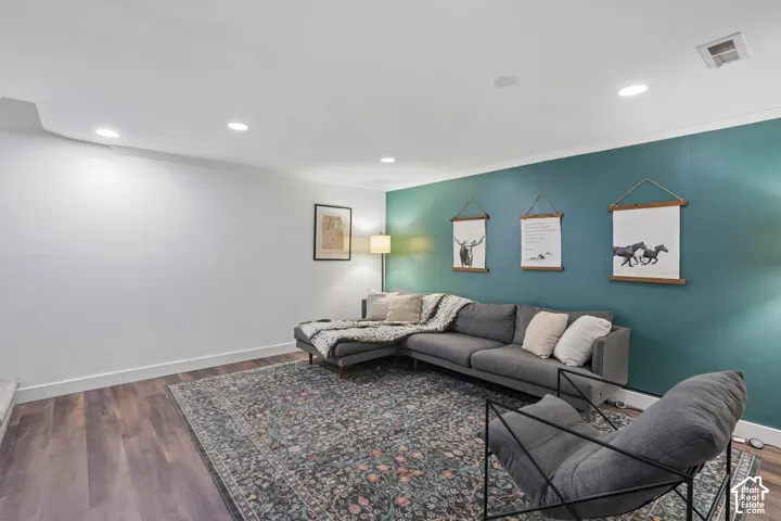 Recessed ceiling lighting, wood-finish flooring, accent wall, white painted walls, and white ceiling trim