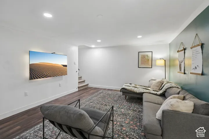Recessed ceiling lighting, wood-finish flooring, accent wall, and staircase access