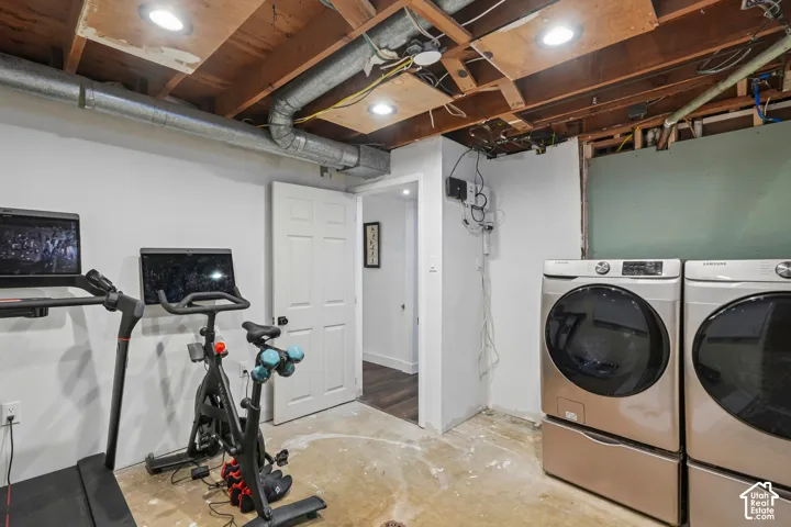 Recessed ceiling lighting, exposed ceiling joists, white painted walls, and concrete flooring