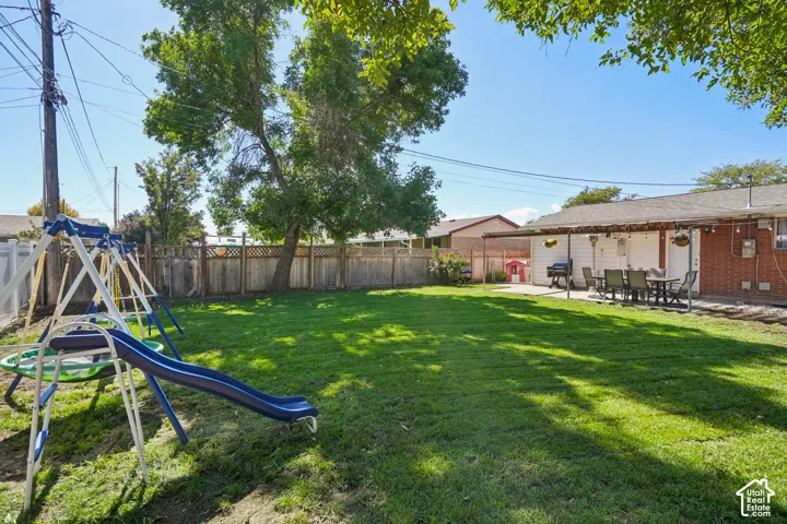 Expansive grassy yard with mature trees, surrounded by wood fencing and a partial white privacy fence