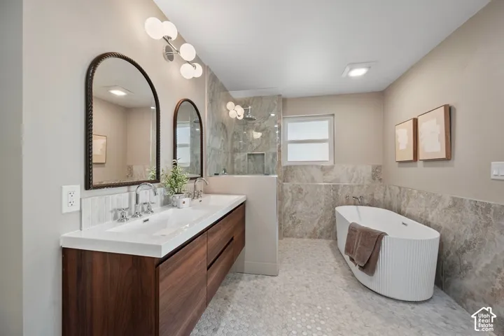 Floating wood-finish double vanity with dual vessel sinks, arched mirrors, and contemporary lighting