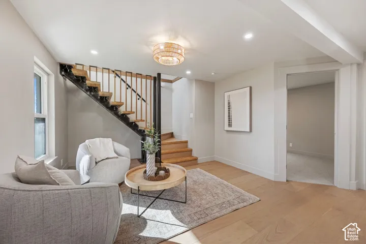 Hardwood-style flooring throughout, open-tread staircase with metal railing, recessed lighting, and a contemporary ceiling fixture