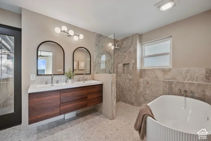 Floating wood-finish vanity with dual integrated sinks, arched mirrors, and contemporary lighting