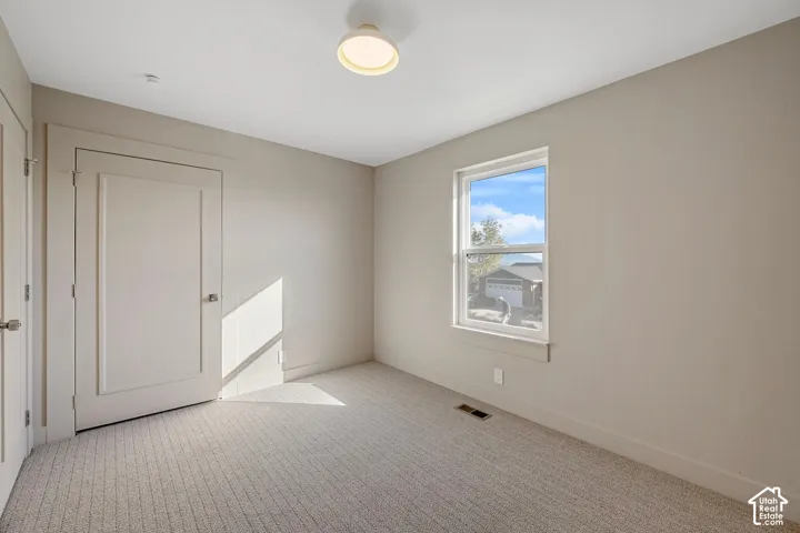 Recessed window with white trim, light neutral wall paint, light-colored carpet, flush-mount ceiling light, and white interior doors