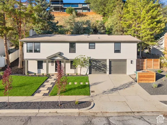 Two-story residence featuring light-toned siding and dark window trim